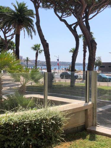a wooden bench in a park with palm trees at T2 & Garage FRONT DE MER résidence de Standing in Fréjus