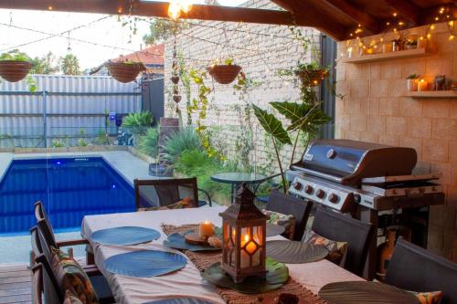 a patio with a table and a grill and a pool at Revive Spa Retreat in Perth