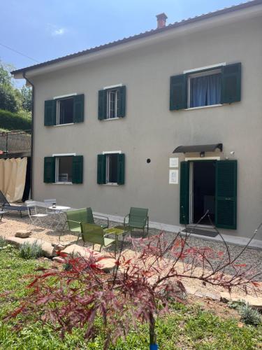 a house with green chairs in front of it at Nina s Casa di Langa in Rocca Ciglie