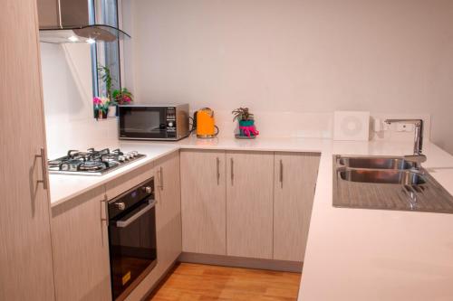 a small kitchen with a stove and a microwave at Revive Spa Retreat in Perth