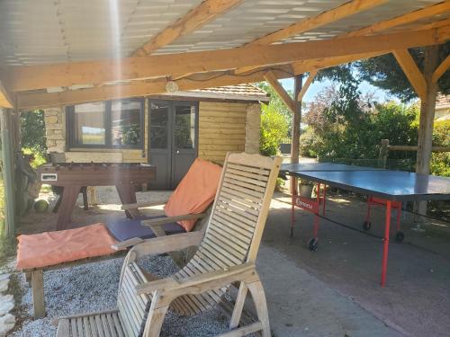 une table et des chaises sous une pergola avec une table et une table de ping-pong dans l'établissement la grange aux hirondelles, à Sancoins