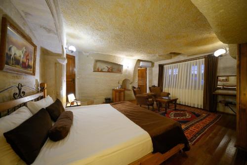 a bedroom with a large bed and a living room at Harman Cave Hotel in Goreme