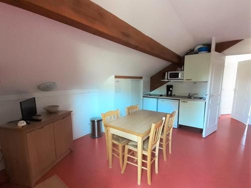 une cuisine et une salle à manger avec une table et des chaises dans l'établissement Appartement Cozy 2 Pièces pour 4 Pers. avec Balcon - Résidence Les Chalets d'Aurouze, La Joue du Loup - FR-1-504-590, à Saint-Étienne-en-Dévoluy