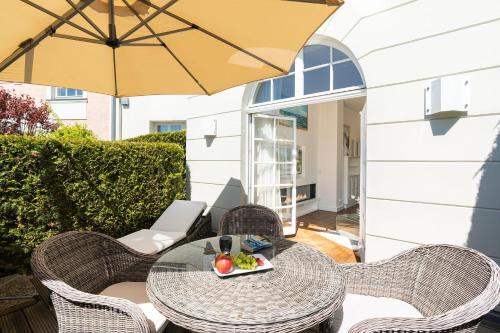 奥斯特西巴德钦诺维茨Villa Gruner App 5的带桌椅和遮阳伞的露台