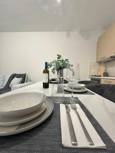 a table with plates and silverware and a bottle of wine at The Lumen in Nea Chili