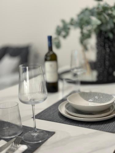 a table with a plate and wine glasses on it at The Lumen in Nea Chili