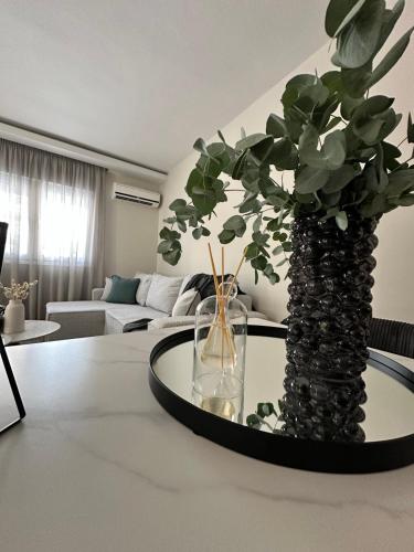 a living room with a table with a vase with a plant at The Lumen in Nea Chili