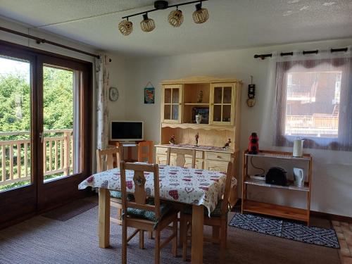 un salon avec une table et une cuisine dans l'établissement Appartement Vue Montagne à 500m des pistes, à Praz-sur-Arly