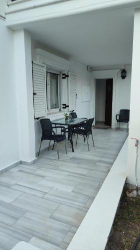 a patio with a table and chairs on a white building at Avaton Myrina Apartment in Myrina