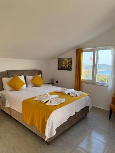 a bedroom with a large bed with yellow pillows at Gökkuşağı Pansiyon in Kaş