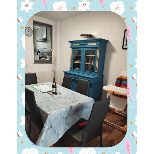 une salle à manger avec une table et un meuble bleu dans l'établissement La maison de Cilou, à Étretat