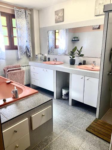 une salle de bain avec deux lavabos et un grand miroir dans l'établissement Pech Joli, à La Dornac