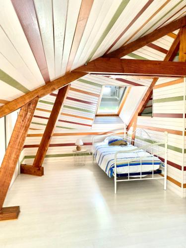 une chambre avec un lit dans une pièce avec des plafonds en bois dans l'établissement Pech Joli, à La Dornac