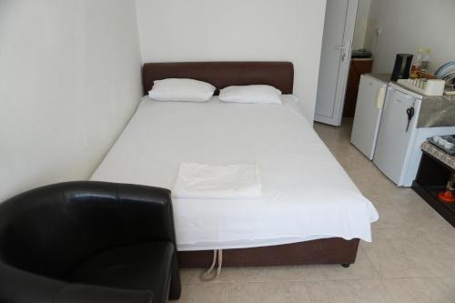 a bed and a chair in a small room at Vila Brca in Brca