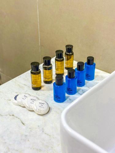 a group of four bottles of essential oils on a bathroom counter at Mona Hotel and Cottages in Lankaran