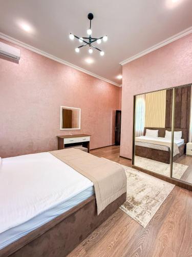 a bedroom with a large bed and a mirror at Mona Hotel and Cottages in Lankaran