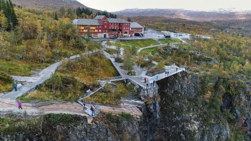 un edificio sul fianco di una montagna con un ponte di Guest favorite - 3 BR Mountain Lodge near Vøringsfossen a Maurset