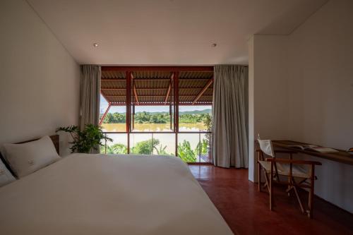 a bedroom with a large white bed and a window at Scarlet Pavilion in Thôn An Vân Thượng