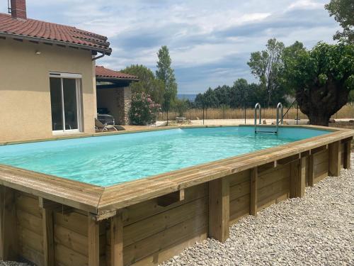 a pool with a wooden deck and a swimming poolitures at Villa Kéana en Sud Ardèche, avec piscine in Lachapelle Sous Aubenas
