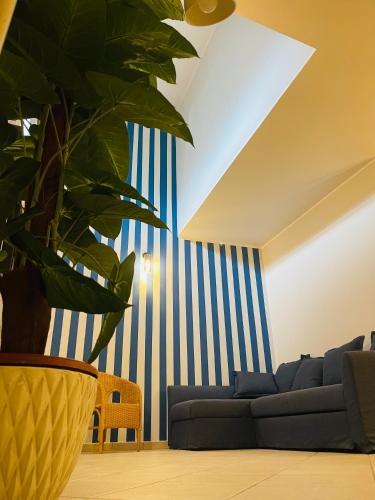 a living room with a blue and white striped wall at Piccolo Da Vinci 17 in Cesenatico
