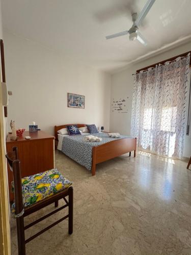 un dormitorio con una cama y una silla en Casa Vacanze Amore, en San Vito lo Capo