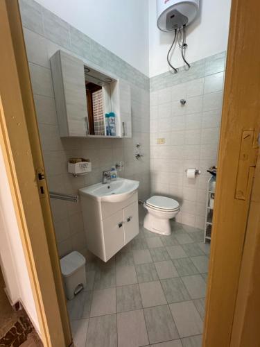 Un baño blanco con inodoro y lavabo. en Casa Vacanze Amore, en San Vito lo Capo