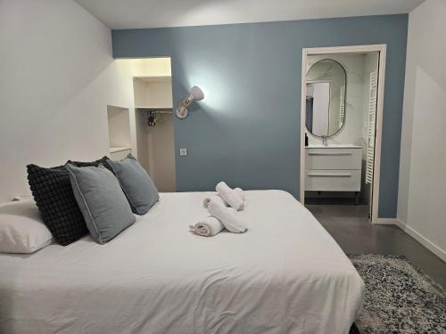 un animal blanc farci assis au-dessus d'un lit dans l'établissement Charme & Clim Place Chateauneuf - Coeur de Tours, à Tours