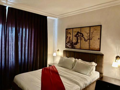 a bedroom with a bed and a painting on the wall at Tamrah Suites Hotel in Amman