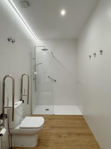 a white bathroom with a toilet and a shower at Apartamentos Nou Mestalla in Valencia
