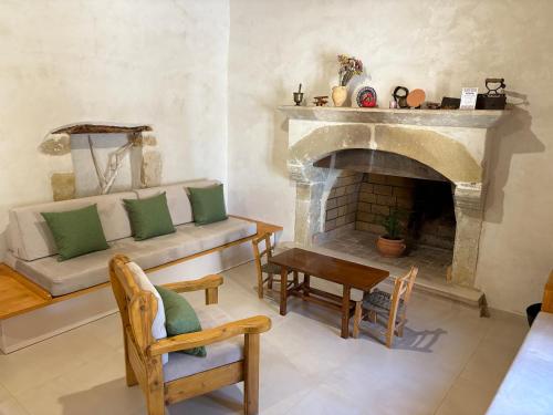 a living room with a couch and a fireplace at Avli House Vori in Vóroi