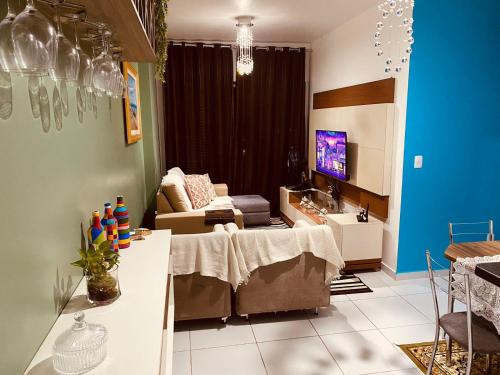 a living room with a table and a couch at Apartamento Confortável! in Maceió