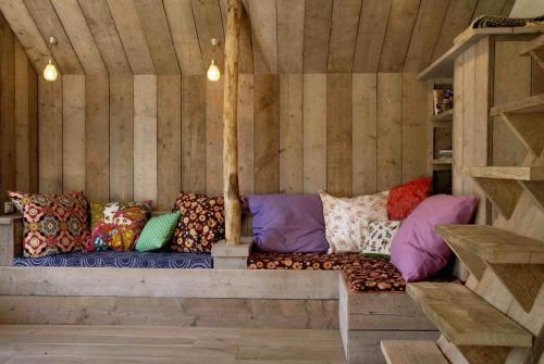 eine Couch in einem holzgetäfelten Zimmer mit Kissen darauf in der Unterkunft Casa di Jardin in Bergen