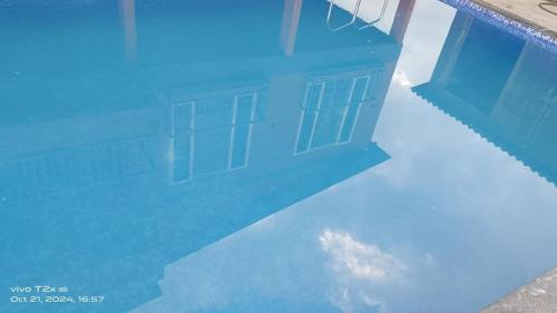 a reflection of a house in a swimming pool at Maharaja foothills Courtyard 4 BHK Villa with Pool in Kolvan
