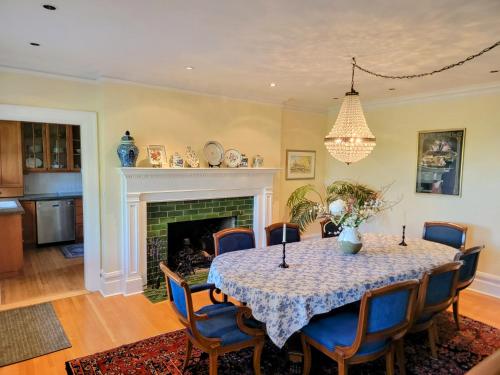a dining room with a table and chairs and a fireplace at Shaughnessy Heritage Manor on Vancouver's Westside free housekeeping optional in Vancouver