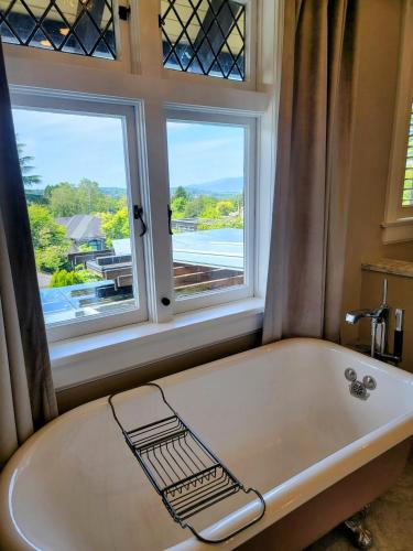 a bath tub in a bathroom with a window at Shaughnessy Heritage Manor on Vancouver's Westside free housekeeping optional in Vancouver