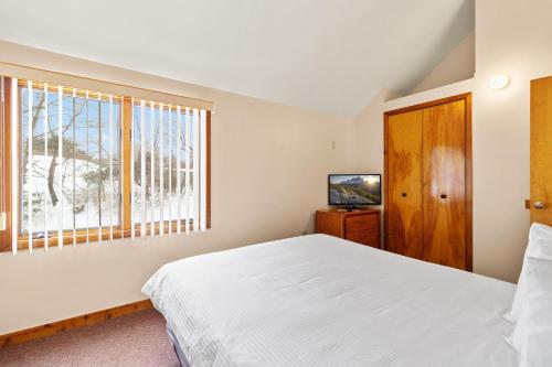 a bedroom with a white bed and a window at Wyndham Shawnee Village 2BR Apartment with Resort Access in East Stroudsburg