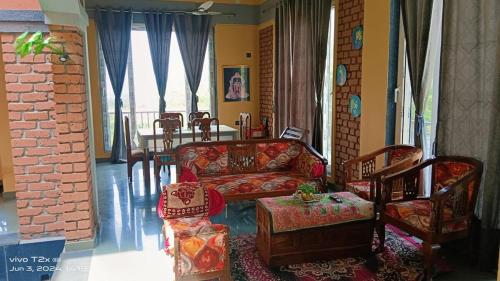 a living room with a couch and a table at Maharaja foothills Courtyard 4 BHK Villa with Pool in Kolvan