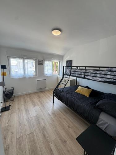 - une chambre avec un lit noir et du parquet dans l'établissement La Croix de Kerbigot - Guidel plage, à Guidel-Plage