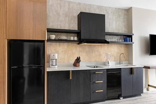 a kitchen with a black refrigerator and a sink at Margaritaville Vacation Club Atlanta Studio Apartment with Resort Access in Atlanta