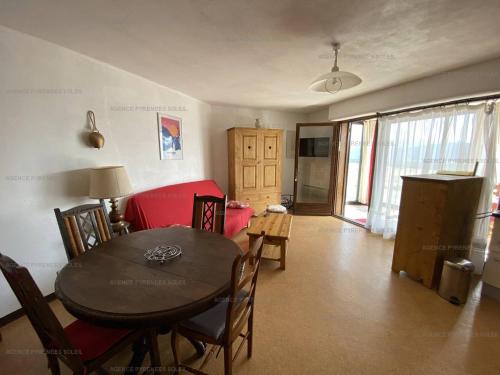 un salon avec une table et un canapé rouge dans l'établissement Bel F2/Cabine Les Angles, proches pistes, parking, classé 1 étoile - FR-1-295-141, aux Angles