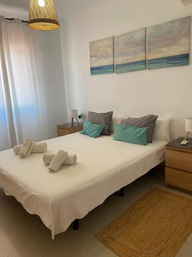 a bedroom with a large white bed with two pillows at Los Alamos in Torremolinos