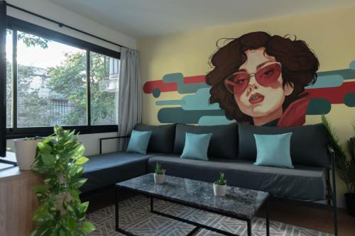a living room with a couch with a painting on the wall at Fliphaus Mansion Paz B - 10 pax Deluxe House Belgrano in Buenos Aires
