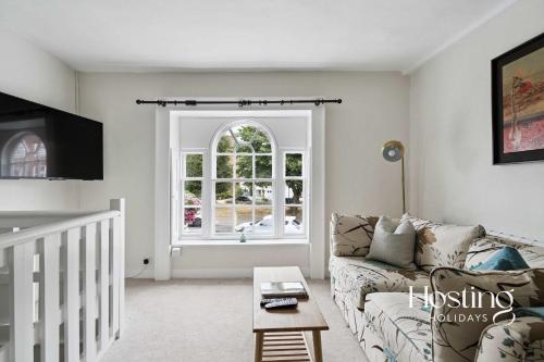 a living room with a couch and a window at Fairmile Loft - Cosy 1-Bed Stay in Central Henley in Henley on Thames