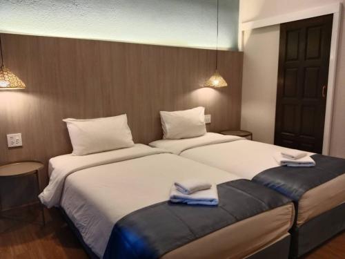 two beds in a hotel room with towels on them at Eastique Hotel Koh Chang in Trat