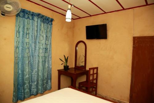 a bedroom with a television and a table with a mirror at Breezy Haven Ella in Ella