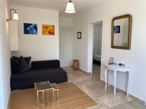 a living room with a black couch and a table at Rez-de-villa dans le calme in Draguignan