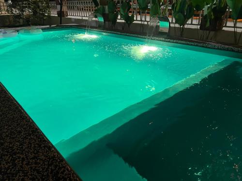 a swimming pool with two water fountains at The White House Nilai Impian in Nilai