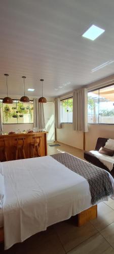 una camera con un grande letto bianco e una cucina di Studio Aconchego Correntina a Correntina