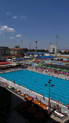 a large swimming pool with a crowd of people in it at Skandik Luxe Residence in Jagodina