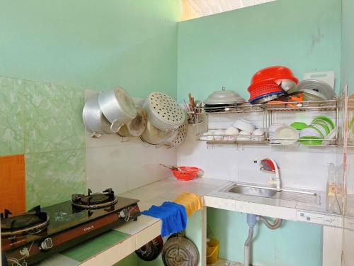 a kitchen with a sink and some pots and pans at Anh Linh Guest House in Mui Ne